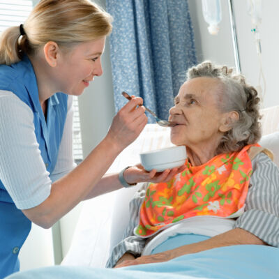 Senior,Woman,90,Years,Old,Being,Fed,By,A,Nurse